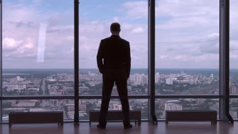 businessman looking at city view from skyscraper