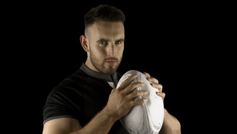 serious rugby player holding ball