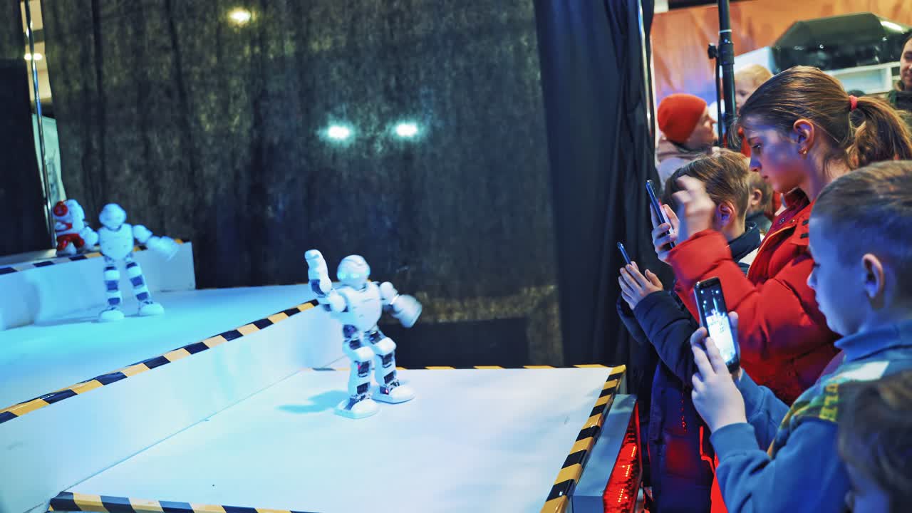 People watch dancing robots at a technology trade show. Robotic dance party. Science Festival