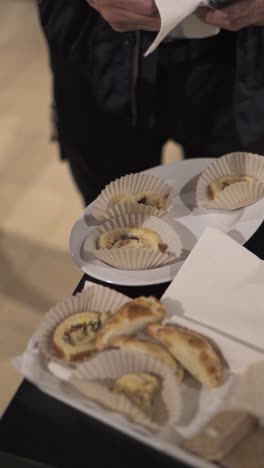 Close-up-of-waiter-offering-variety-plate-of-small-desserts-and-appetizers-in-banquet-service