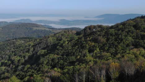 Aerial-drone-panoramic-view-from-Uchon-Mountain-with-fog-shrouded-rural-landscape-in-background,-France