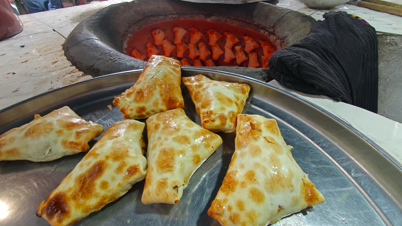 Freshly Baked Samosas on a Tray Near a Tandoor Oven