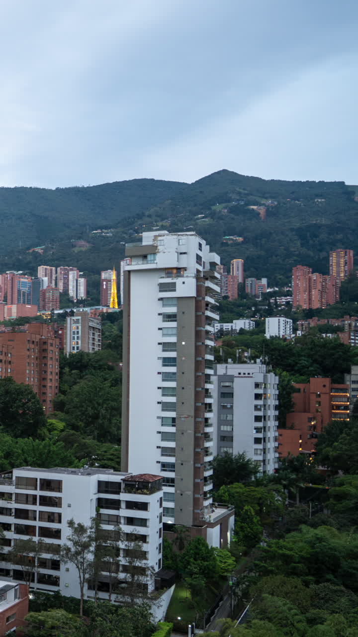 Ammira una splendida vista aerea al tramonto di El Poblado, Medellín. Il video verticale mostra il paesaggio urbano, le montagne e le vivaci luci della città, perfetto per storie sui social media e dispositivi mobili.