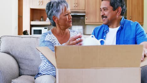 Senior-couple-looking-at-teapot-in-living-room-4k