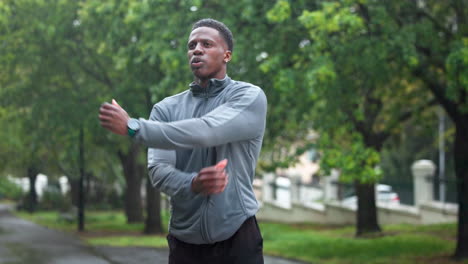 man stretching outdoors in the rain