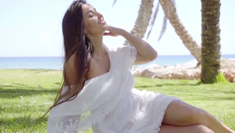 gorgeous lady sitting among palm trees