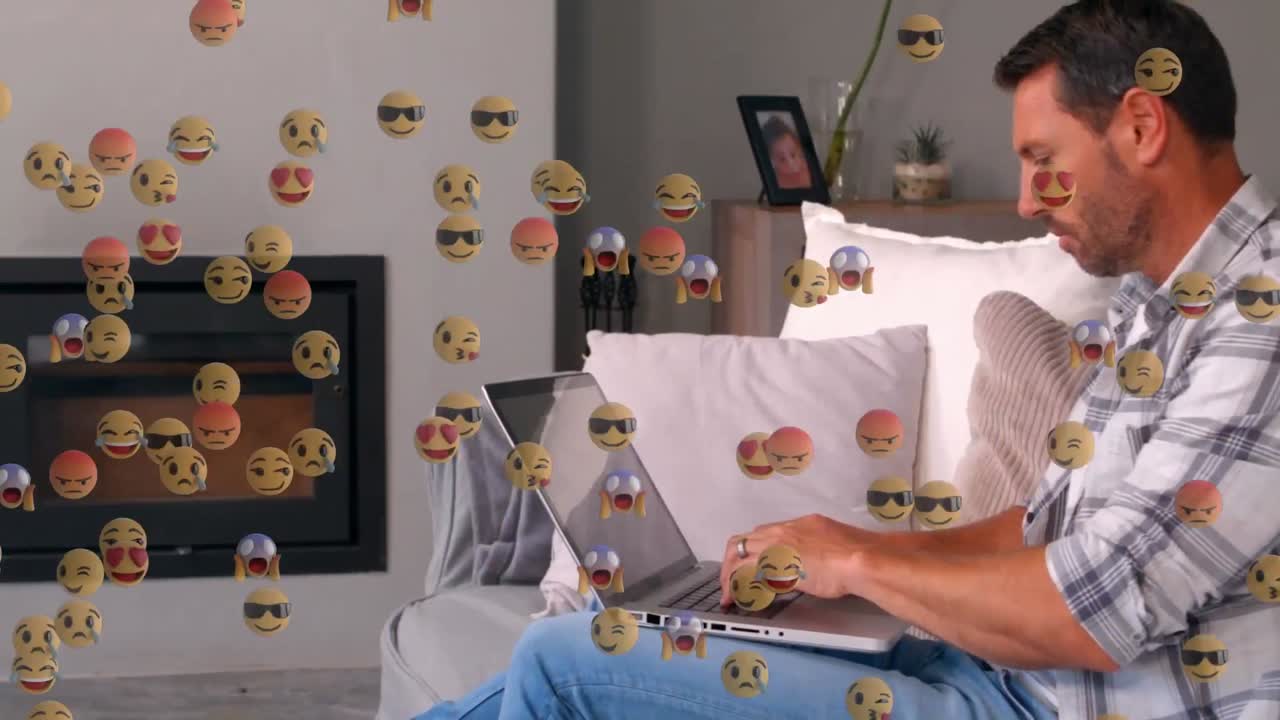 animación de iconos emoji sobre un hombre caucásico usando una computadora portátil en casa