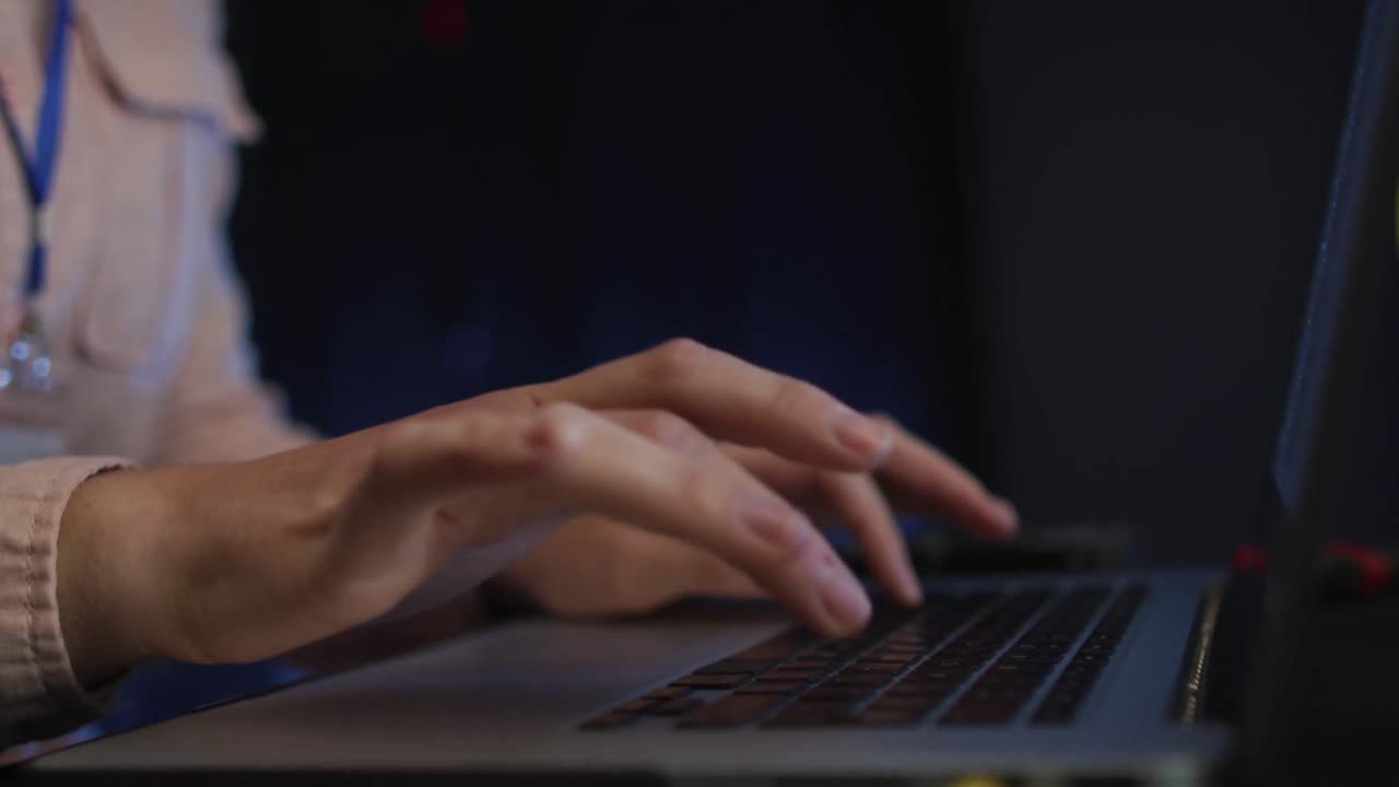 Midsection of female it technician typing on laptop keyboard