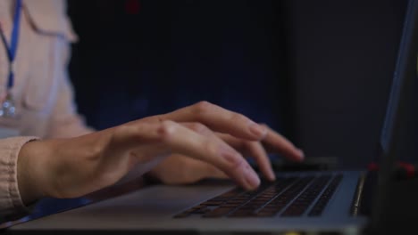 midsection of female it technician typing on laptop keyboard