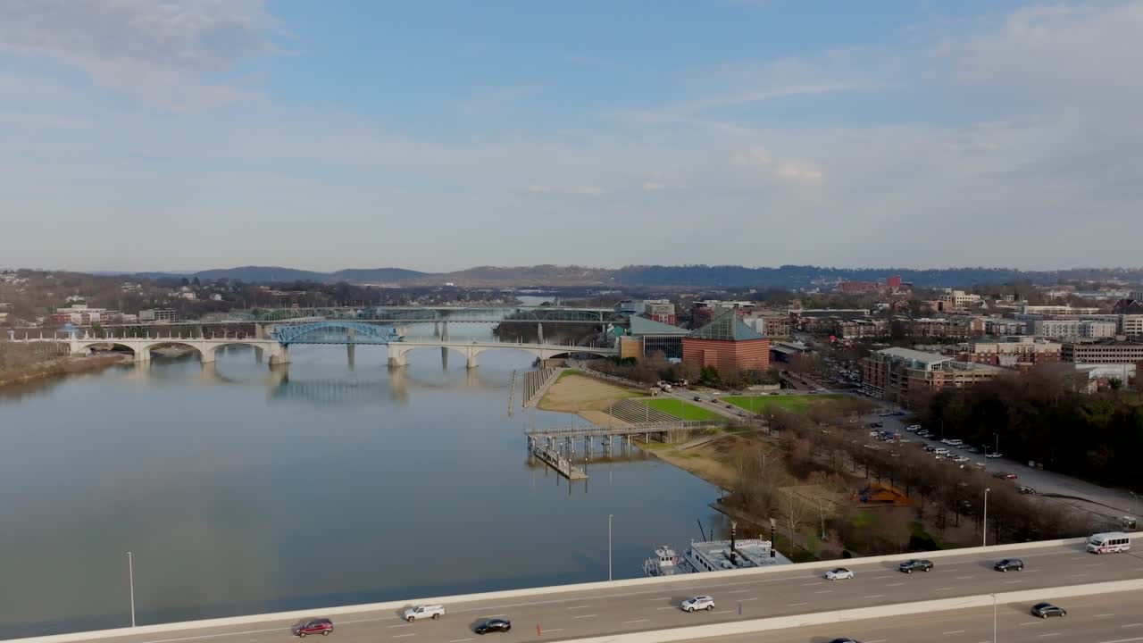 Aerial footage flying by a bridge with a view of the Tennessee Aquarium in Chattanooga, TN.