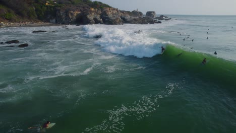 Welle,-Die-In-Einer-Surfzone-Vorrückt,-Und-Einige-Leute,-Die-Professionell-Surfen