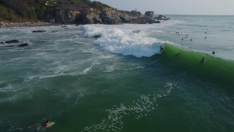 wave advancing in a surf zone, and some people surfing professionally