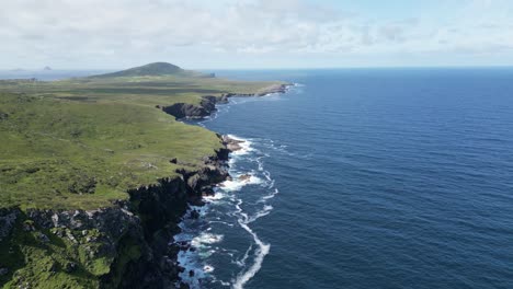 Küste-Der-Insel-Valentia-Mit-üppigem-Grün-Und-Brechenden-Wellen,-Luftaufnahme