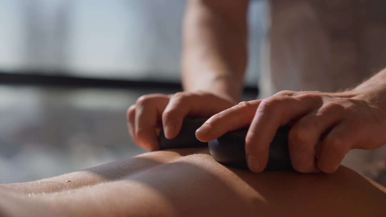 Nærbillede af hot stone massage på en persons ryg