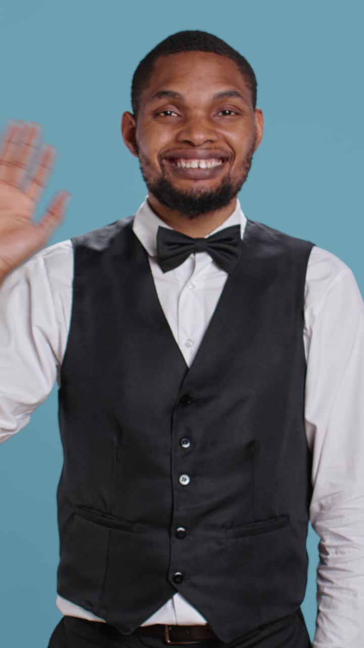 Friendly Waiter in Uniform Waving and Bowing