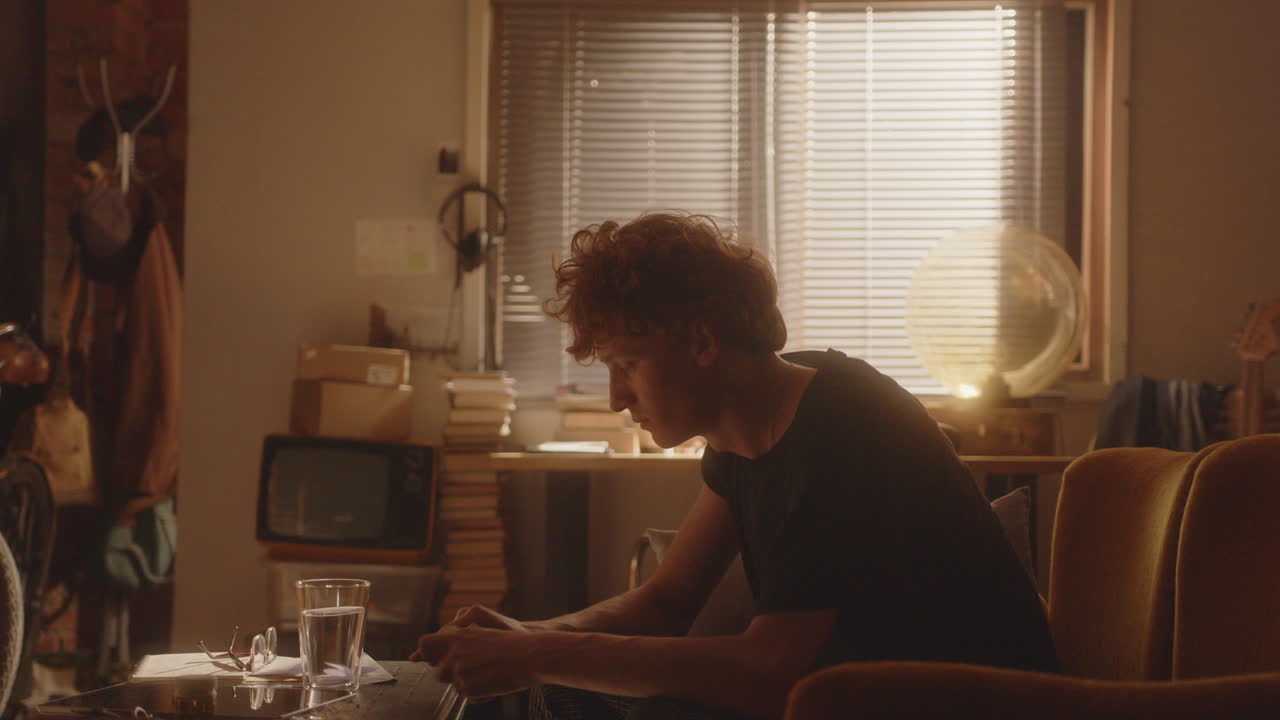 편안한 방에서 항우울제를 복용하고 물을 마시는 젊은 남자