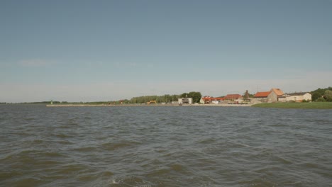 Vista-Lejana-De-La-Ciudad-Costera-De-Frombork-A-Través-De-La-Laguna-De-Vistula-En-El-Condado-De-Braniewo,-Polonia