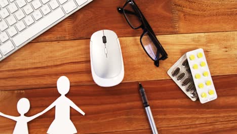 papel cortado de una familia con tableta, bolígrafo, estetoscopio, clipboard, gafas y medicina