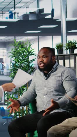 vertical video multiethnic professionals in a heated argument during corporate negotiation