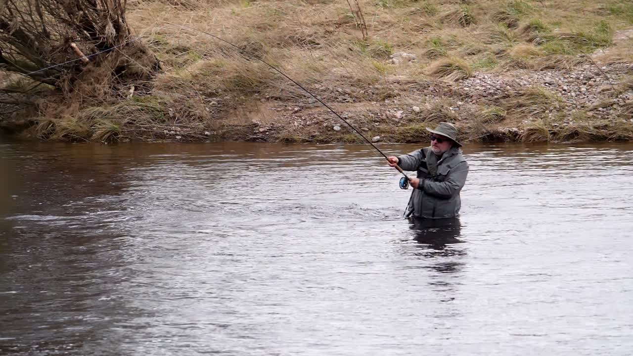 Angler fishing for salmon on the river Dee in Scotland