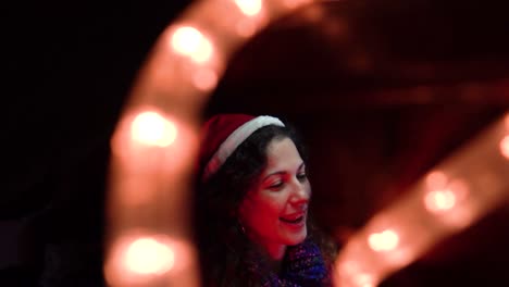 a young woman wearing a festive santa hat plays christmas music on a beautifully decorated piano with warm lights for holiday joy and musical traditions.