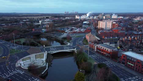 aerial early morning city street traffic commuting intersection lanes crossing curved river orbit right