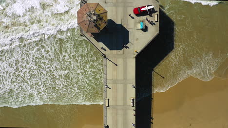 imágenes de drones de personas caminando en un muelle, en el océano, tomadas de un drone