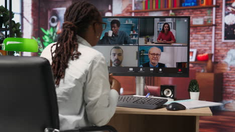 remote worker in home office saluting coworkers during internet videocall