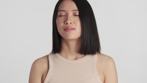 Asian-woman-with-eyes-closed-relaxing-on-camera.