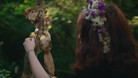 young druid girl contemplates her wooden staff close up shot