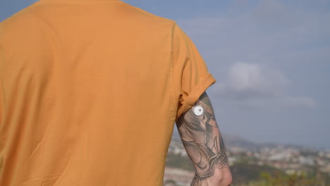 Man-with-glucose-level-remote-sensor-on-tattooed-arm-to-control-diabetics-blood-sugar-level