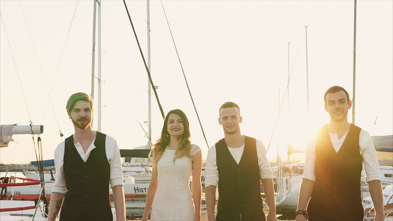 Group of friends walking on a dock at sunset