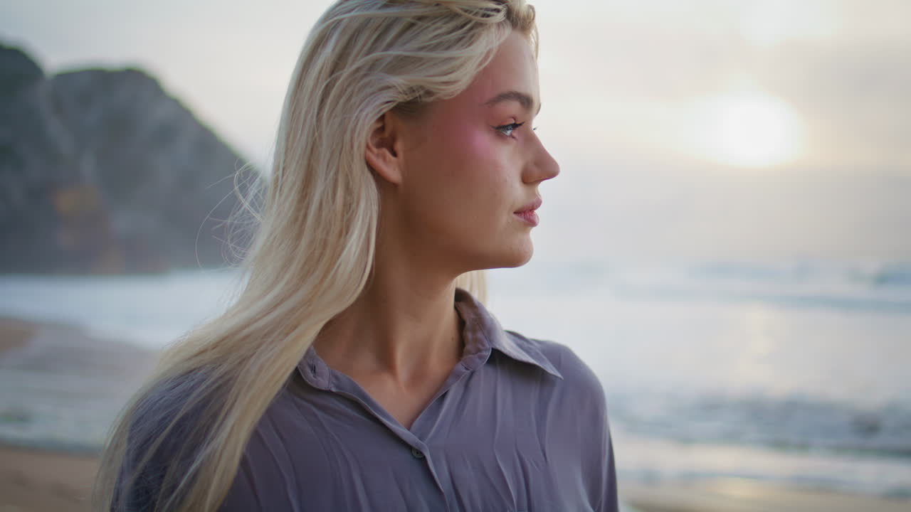 Ritratto di ragazza che sogna il cielo al tramonto sull'oceano. Donna contemplativa che si gode il mare sereno.
