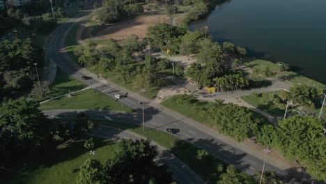 vista aérea de arriba hacia abajo de un parque con autopista siguiendo la curva de dirección con el tráfico revelando el entorno urbano en río de janeiro al amanecer