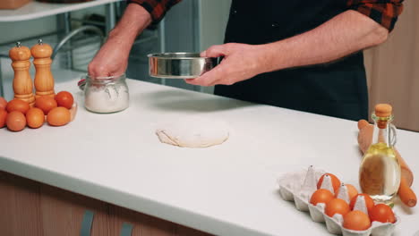 Man-sifting-flour-with-sieve