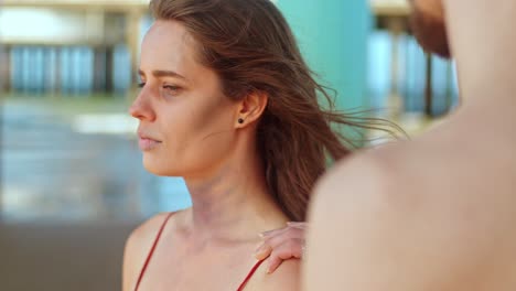 a man looks stunned as he notices a woman who has been harmed on the beach - close up