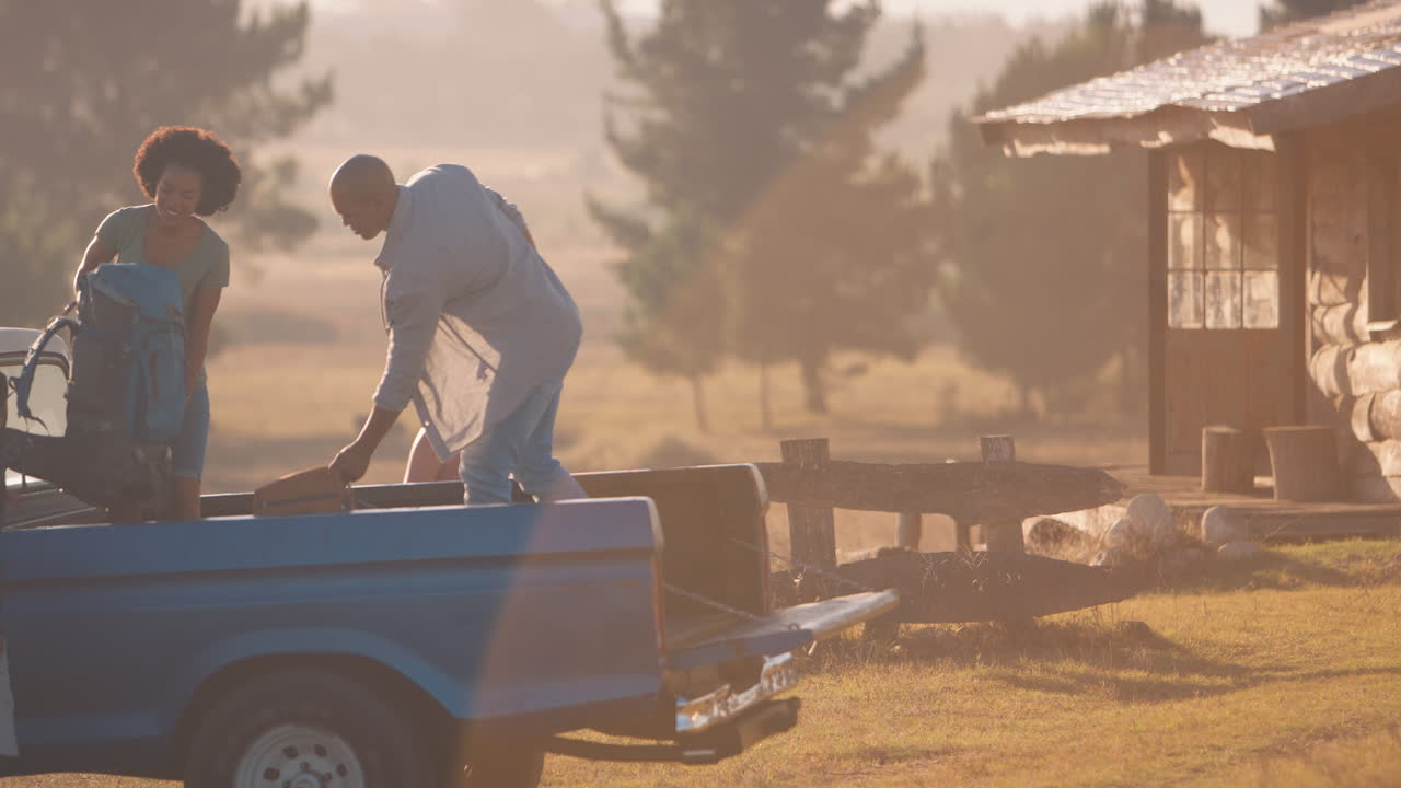 한 무리의 친구 들 이 트럭 에서 배 ⁇  을 풀고 시골 에 있는 오두막 으로 도로 여행 을 하고 있다