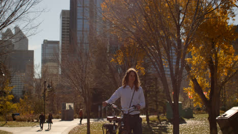 vue de devant d'un jeune homme caucasien marchant avec un vélo dans la rue 4k