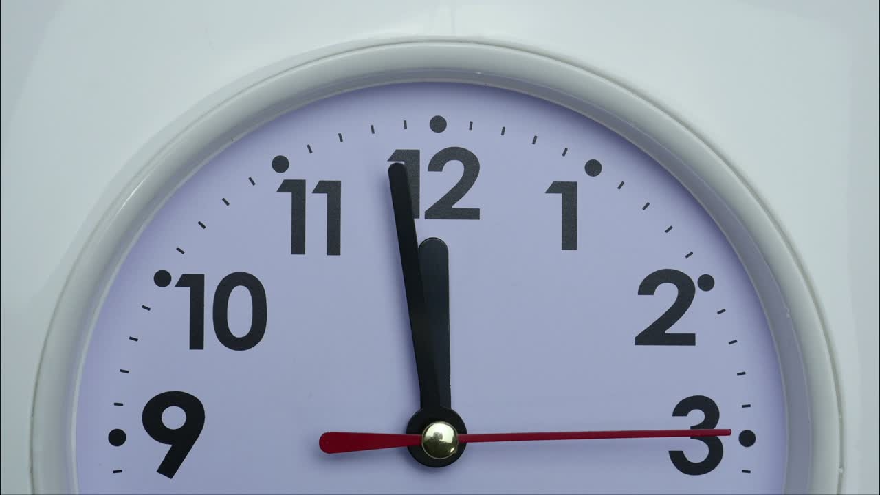 Video in time-lapse di un orologio da parete bianco che mostra le 12 e 15 minuti