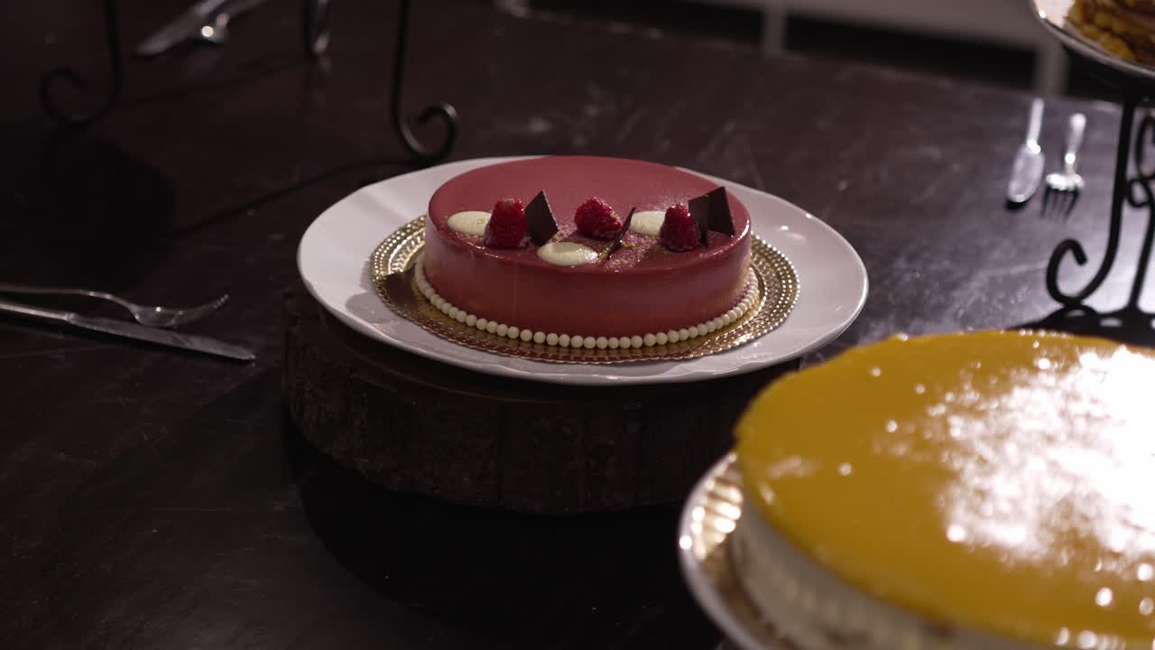 Raspberry and mango mousse cakes with chocolate and fruit garnish on plates