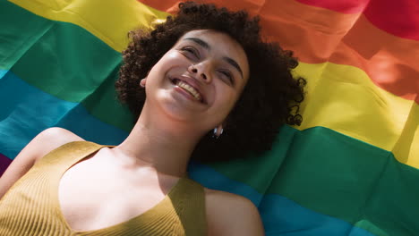 mujer acostada sobre la bandera del orgullo