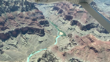 épica vista aérea panorámica sobre el colorido gran cañón y el río colorado desde el interior de pequeños aviones que vuelan por encima, de mano