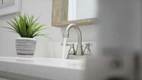 Close-up-pan-of-faucet-with-running-water