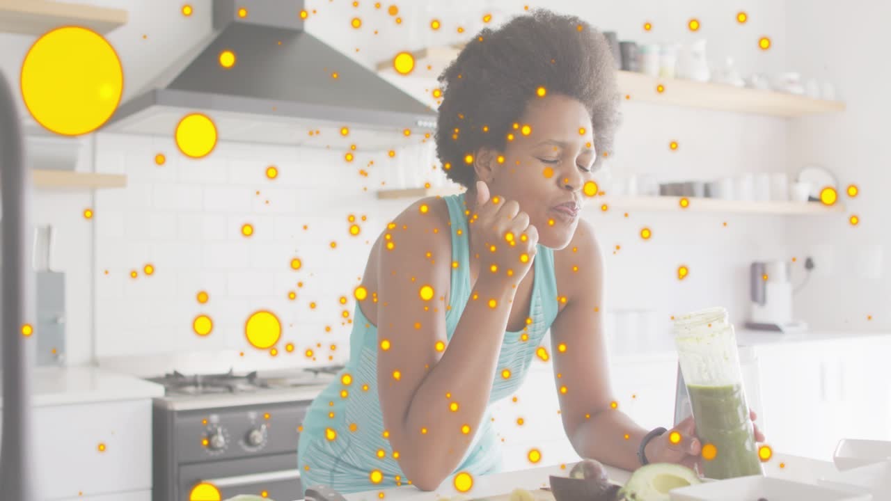 Mulher levando o dedo aos lábios provando um smoothie verde, pontos amarelos flutuando sobre o pote testando a saúde