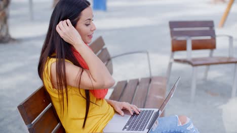 Stilvolle-Junge-Frau,-Die-Draußen-An-Einem-Laptop-Arbeitet