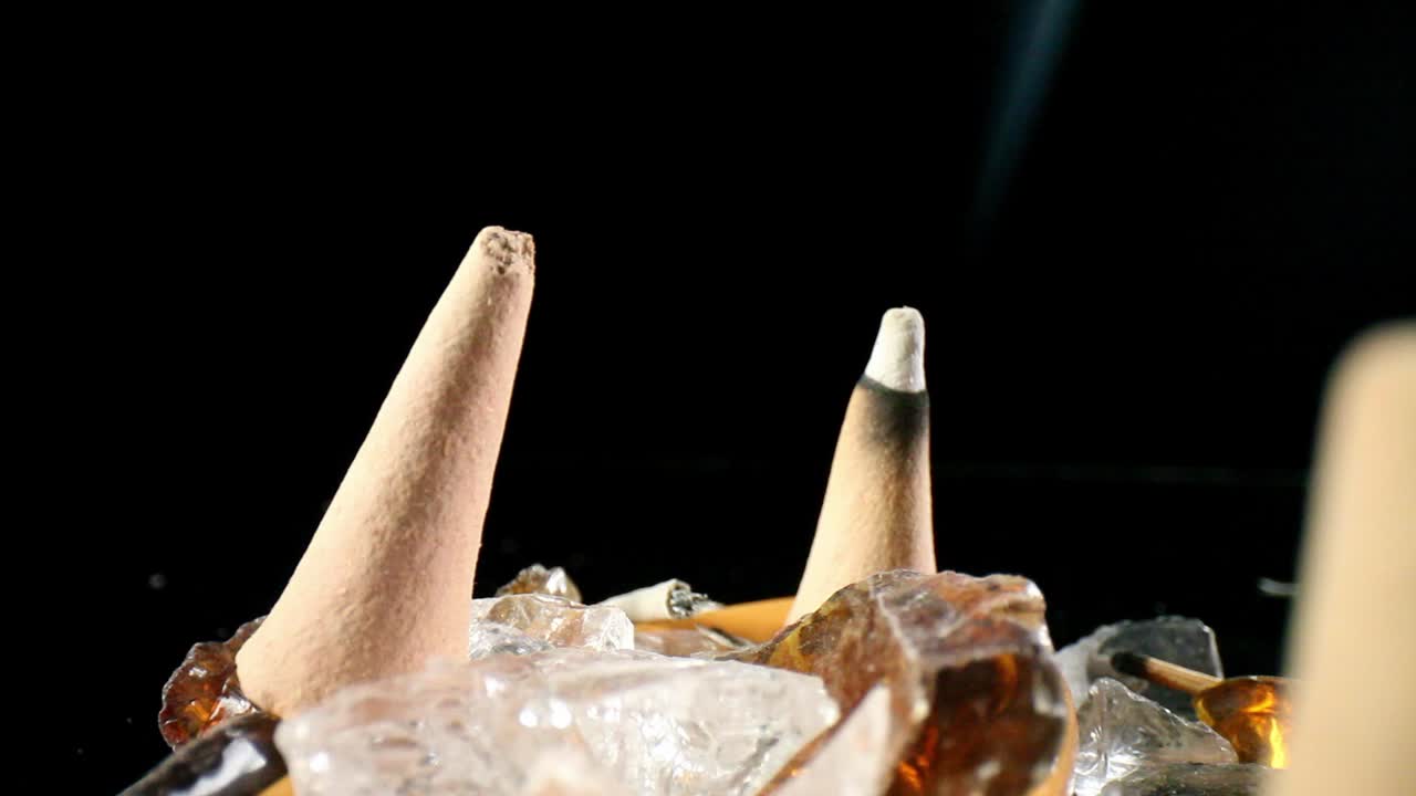 alejándose de un cono de incienso encendido, una delgada línea de humo se eleva