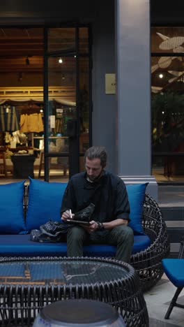 man sitting on a blue couch reading