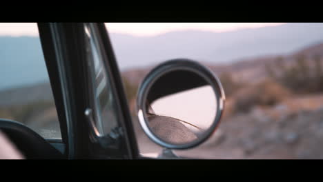 view through closing side window of a classic car in motion