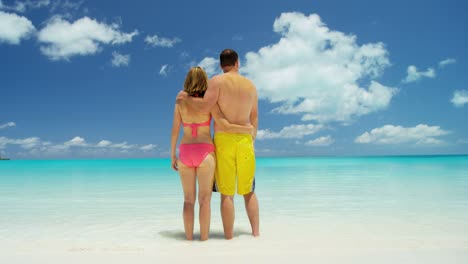 caucasian couple on white sand beach in swimwear