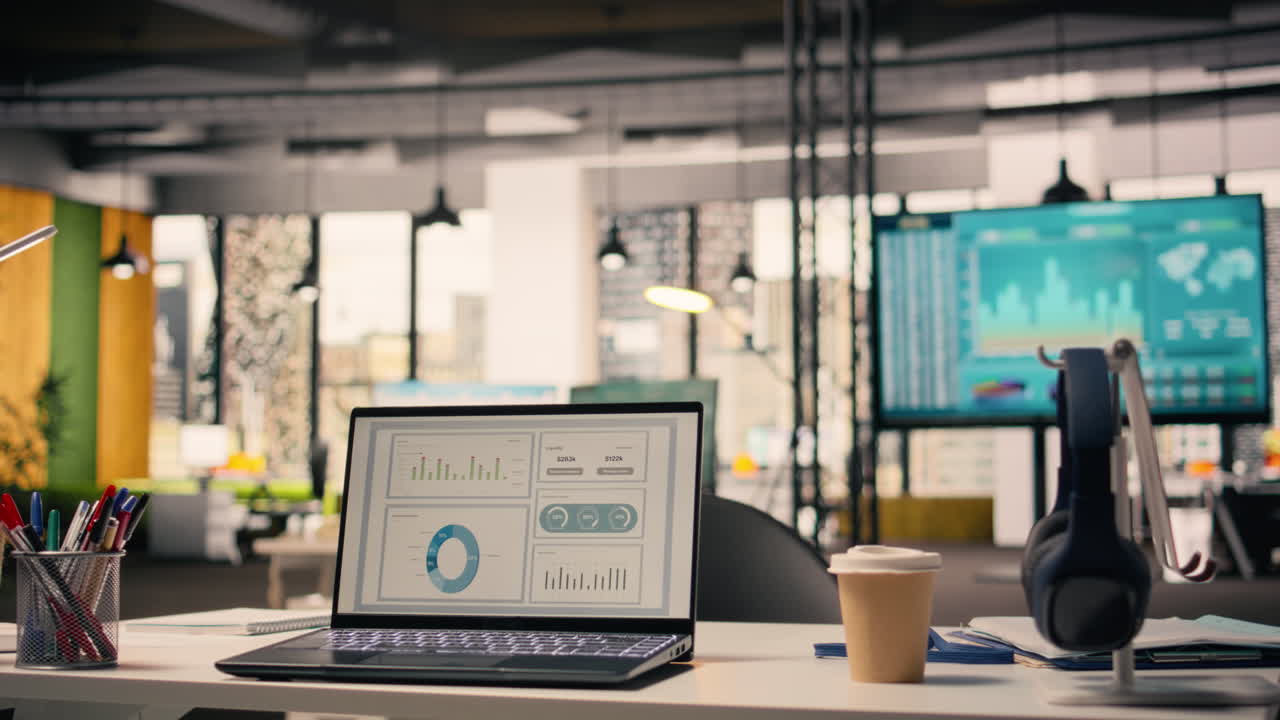 Performance metrics running on laptop screen in empty open office with supplies